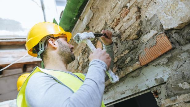 Close-up of worker working with hammer and chisel